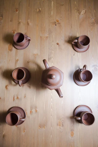 Teekanne und Tassen aus Ton auf einem Holztisch — Stockfoto