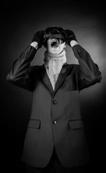 Closeup of a man wearing a chain around his neck with his mouth wide open in a dramatic scream. High contrast on black background — Stock Photo, Image