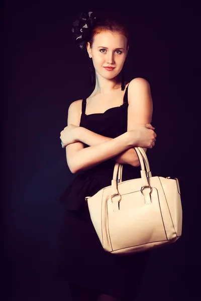 Красивая молодая женщина с большой желтой сумкой стоит позируя — стоковое фото