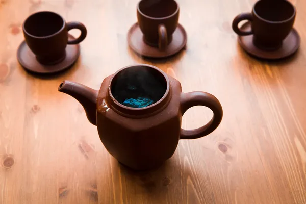 Bule de barro e xícaras em uma mesa de madeira — Fotografia de Stock