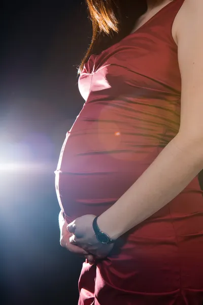 おなかと胎児の開発と成長を確認する彼女の腹を測定非常に突出の膨らみの双子を期待して妊娠中の女性の手のトリミング ビュー ストック写真
