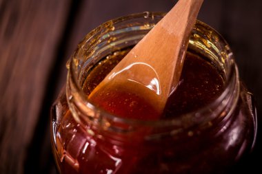 siyah arka plan üzerine bir tahta bal ayı den damlayan bal