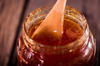 siyah arka plan üzerine bir tahta bal ayı den damlayan bal