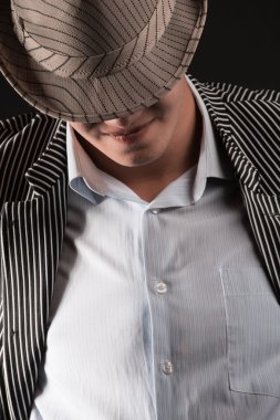 siyah arka plan üzerine gri şapkalı bir adam