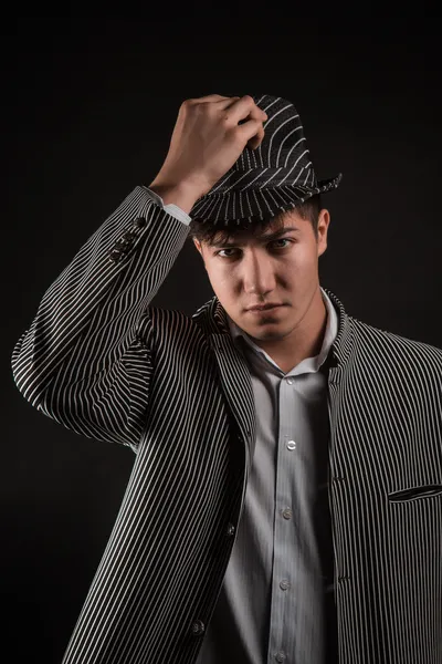 Человек в серой шляпе на черном фоне — стоковое фото
