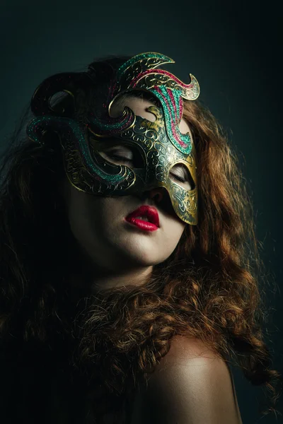 Vacker flicka i carnival mask med långt lockigt hår. maskerad semester — Stockfoto
