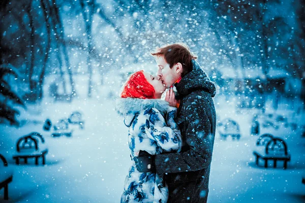 Jovem casal feliz no Parque de Inverno se divertindo. Família ao ar livre. beijo de amor — Fotografia de Stock