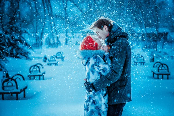Jovem casal feliz no Parque de Inverno se divertindo. Família ao ar livre. beijo de amor — Fotografia de Stock