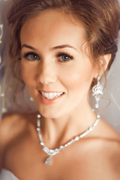 Beautiful Bride lit by sunlight from a window. beautiful young bride standing beside a large window — Stock Photo, Image