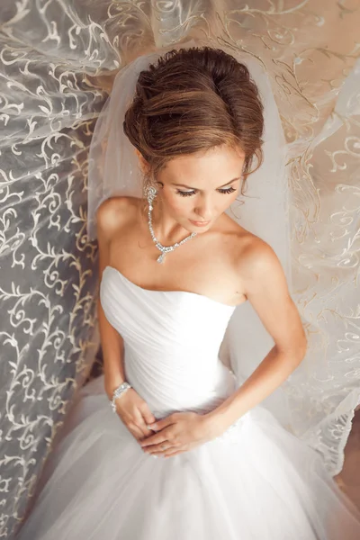 Beautiful Bride lit by sunlight from a window. beautiful young bride standing beside a large window — Stock Photo, Image