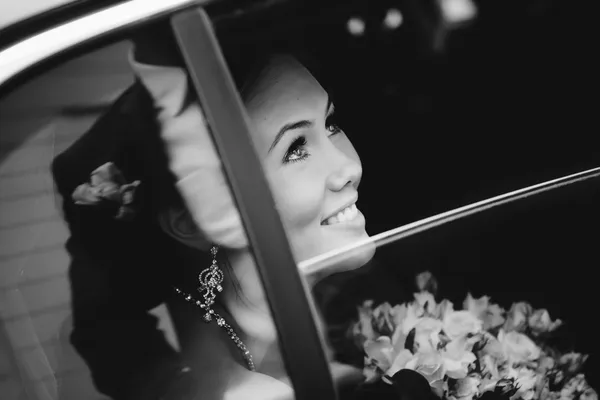 Glückliche Braut im Fenster einer Hochzeitslimousine — Stockfoto