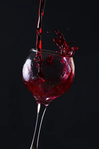Glass of champagne with splash, isolated on black background — Stock Photo, Image