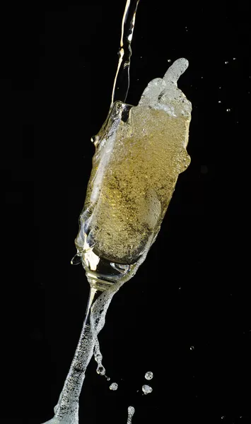 Glas Champagner mit Spritzer, isoliert auf schwarzem Hintergrund — Stockfoto