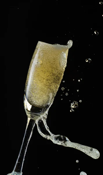 喝杯香槟时溅起水花，黑色的背景上孤立 — 图库照片