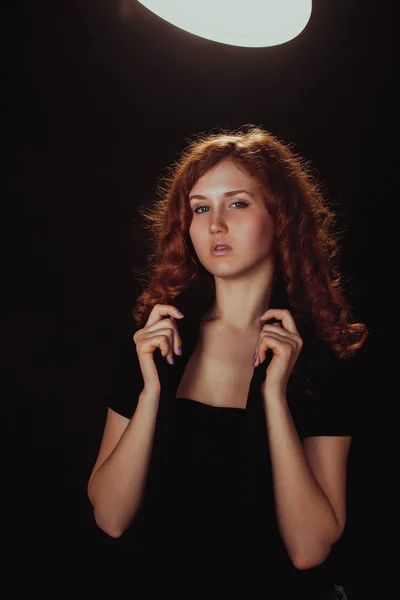 Portrait of a glamorous young woman on dark background — Stock Photo, Image