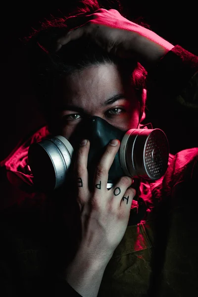 A man in a gas mask on a black background — Stock Photo, Image