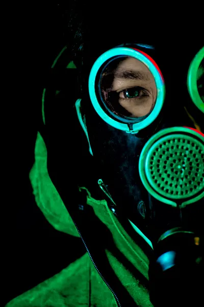 Un homme avec un masque à gaz sur fond noir — Photo