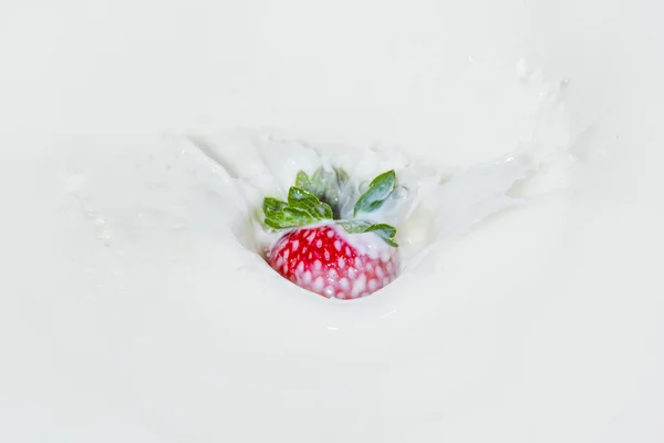 Strawberry falling into splashing milk. Isolated on white. — Stock Photo, Image