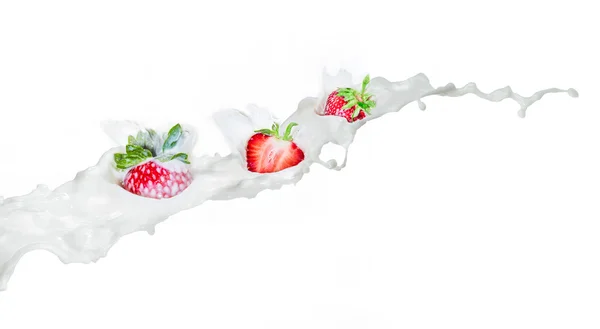 Erdbeere, die in spritzende Milch fällt. isoliert auf weiß. — Stockfoto