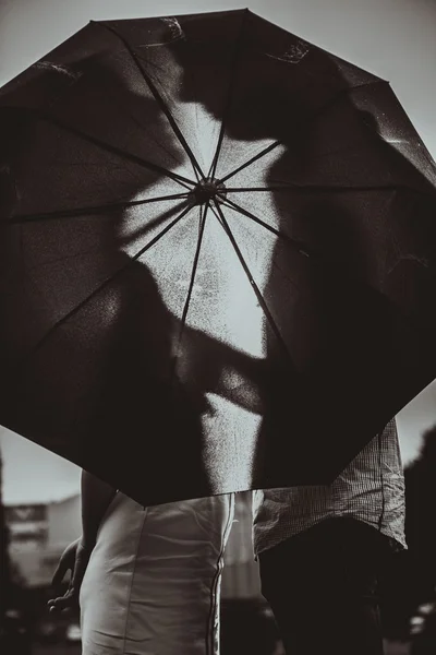 Silueta de pareja besándose bajo paraguas — Foto de Stock