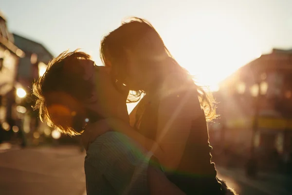 Fiatal pár csókolózik naplemente felett — Stock Fotó