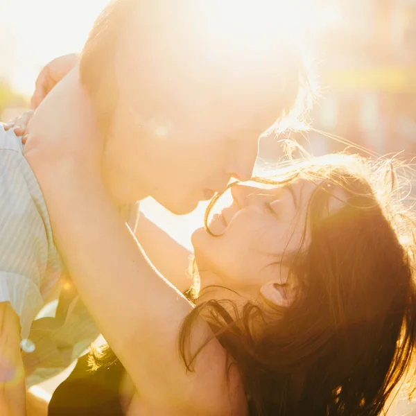 一对年轻夫妇在夕阳下接吻 — 图库照片