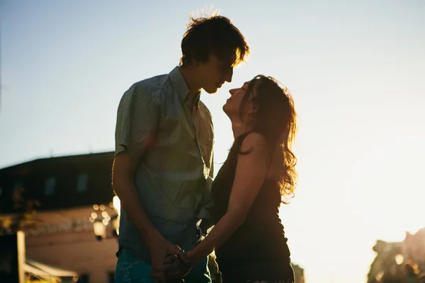 Jeune couple embrasser sur le coucher du soleil — Photo