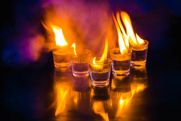 Gläser mit brennendem Alkohol auf schwarzem Hintergrund — Stockfoto
