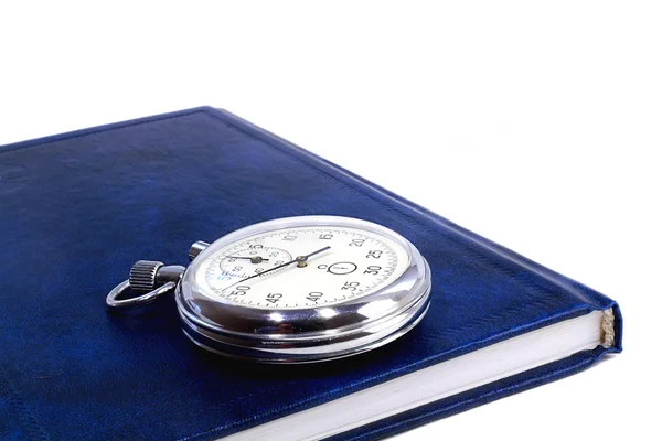 Cronómetro y el cuaderno sobre un fondo blanco — Foto de Stock