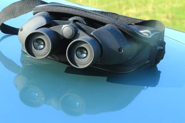 Binoculars in the pouch on the hood of the car. — Stock Photo, Image