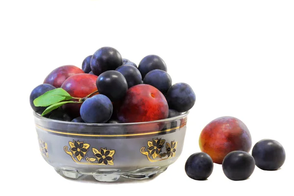 Pflaumen und Pflaumen in einer Vase für Obst auf weißem Hintergrund. — Stockfoto