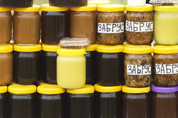 Různé druhy medu v bankách, nabízeny k prodeji na f — Stock fotografie