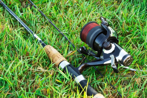 Spinning fishing on the green grass by the river. Stock Picture