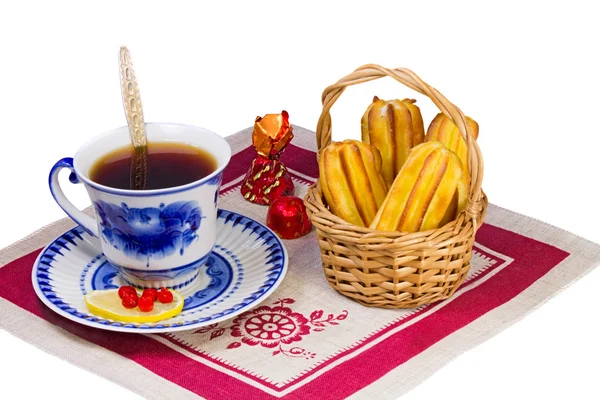 Taza de té, dulces y pasteles en una canasta de mimbre . — Foto de Stock