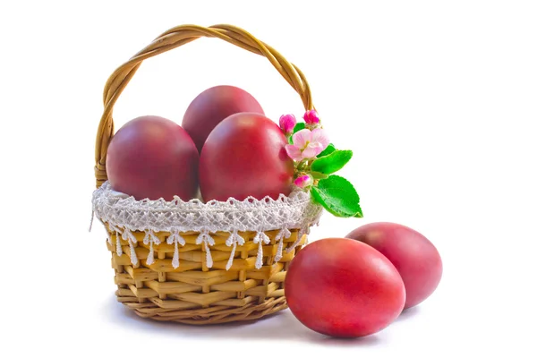 Huevos rojos de Pascua en una canasta sobre un fondo blanco . —  Fotos de Stock