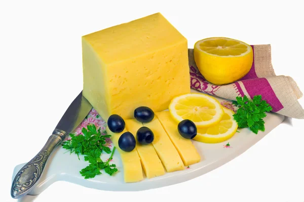 Gran trozo de queso, limón y aceitunas sobre un fondo blanco . — Foto de Stock