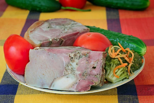 Carne di maiale affumicata e verdure su un piatto bianco — Foto Stock
