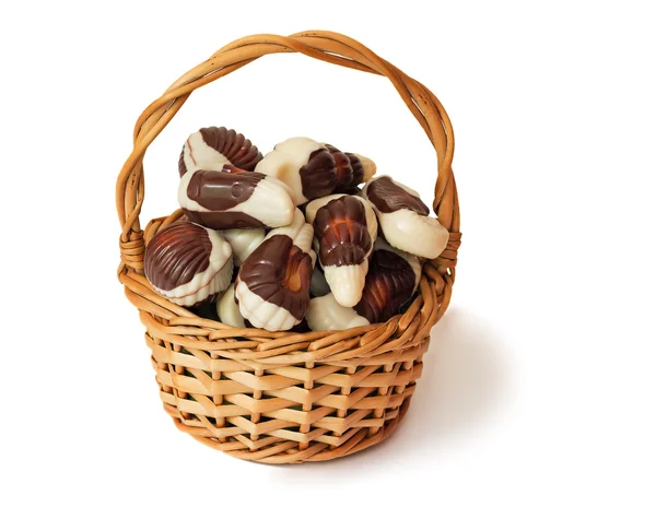 Cioccolatini in un cesto di wattled su uno sfondo bianco . — Foto Stock