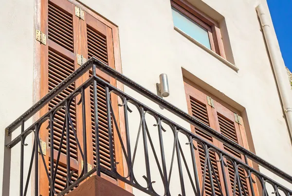 Fragment of a facade of a house with a balcony and blinds from t — Stock Photo, Image