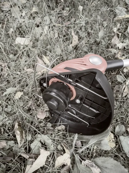 Gräsklippare, batteri trimmer på bakgrunden av trädgården — Stockfoto