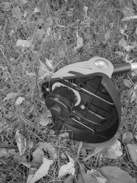 Sekačka na trávu, vyžínač baterií na pozadí zahrady — Stock fotografie