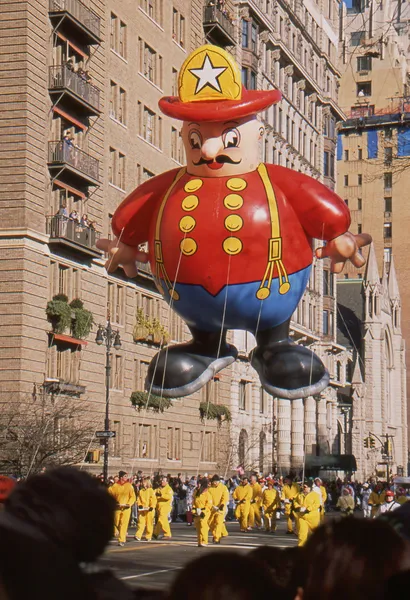 NEW YORK-NOV 22: A holiday tradition since 1924, the annual Macy's Thanksgiving Day Parade is seen by more than 3.5 million people. Pictured here in 2012 is the Harold the Fireman balloon. — Stock Image NEW YORK-NOV 22: A holiday tradition since 1924, the annual Macy's Thanksgiving Day Parade is seen by more than 3.5 million people. Pictured here in 2012 is the Harold the Fireman balloon. Stock Photo