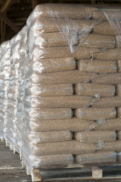 Pallets of Heating pellets in plastic bags. Fuels from coniferous shavings.