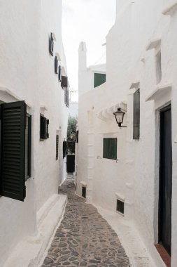 Menorca 'da eski bir beyaz köyde, kaldırım taşı sokağında dar bir sokak köşesi.
