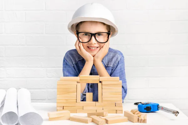 Engenheiro Menino Sorridente Capacete Construção Constrói Uma Casa Blocos Madeira Imagem De Stock