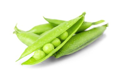 Beyaz zemin üzerinde su damlaları olan taze taze bezelye tohumları. Bir yığın tatlı baklagil izole edilmiş. Sağlıklı beslenme ve çiğ organik gıda malzemeleri..