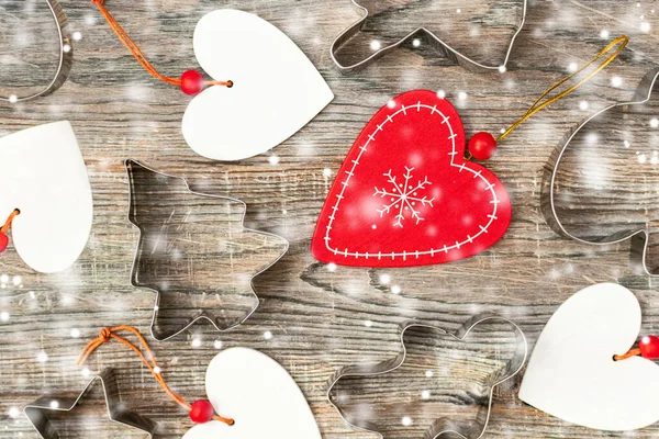 エコ木製の心と雪のフレークと茶色の木製の背景にクリスマスツリー スター ジンジャーブレッドマンと天使の形の金型のベーキングフォームを持つメリークリスマスの背景 明けましておめでとうございます — ストック写真