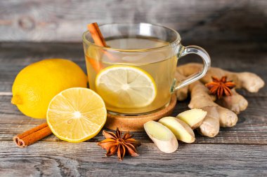 Taze zencefil kökü, limon ve ahşap zemin üzerinde anason ve tarçın baharatlarından yapılmış çay. Doğal organik antiflu malzemeler, alternatif tıp, bağışıklık desteği. Enerji içeceği..