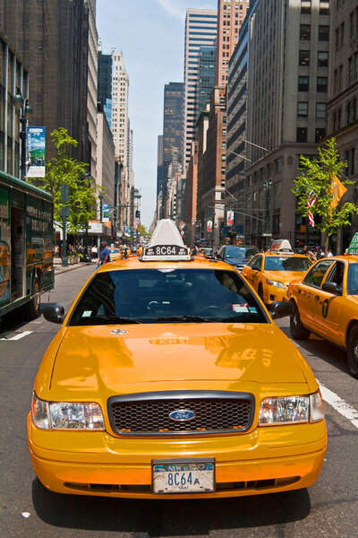 Manhattan buildings and taxis driving on a sunny day, New York City, USA