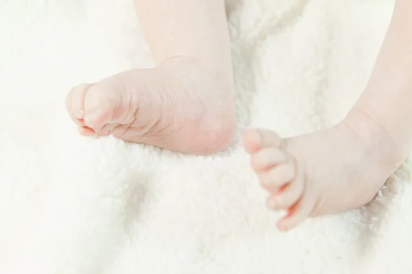 Pequeños pies de bebé en una cama —  Fotos de Stock